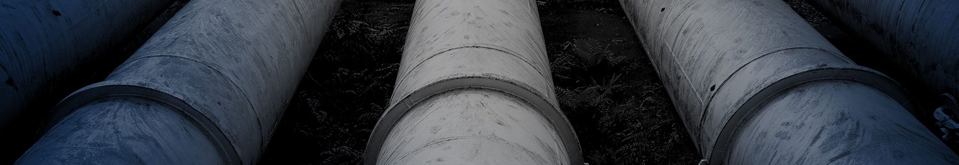 Large industrial pipes laid in a row, black and white image