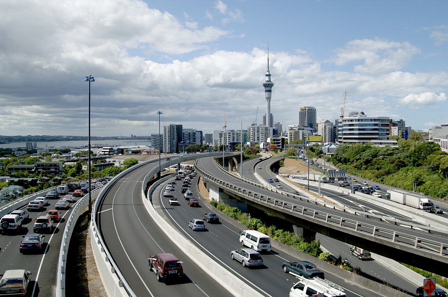 Late afternoon traffic in Auckland, New Zealand; downtown skyline with Sky-Tower in the background