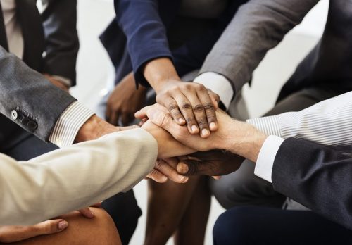 Business workers putting their hands in for a huddle